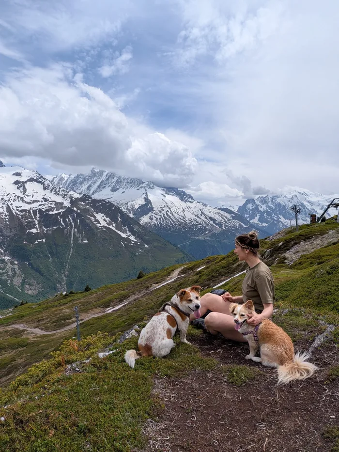 Diana, hiking in the mountains, with two of their adopted dogs